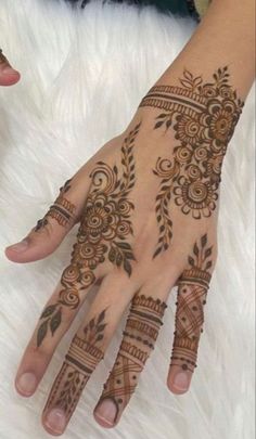 two hands with henna tattoos on them