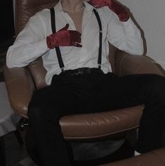 a man sitting in a chair wearing red gloves