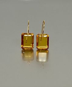 Exquisite faceted Citrine earrings featuring flawless rectangle-shaped drops. These Citrine drops showcase a flawless, rich golden hue and are gracefully attached to your choice of 24K Gold Vermeil or 14K SOLID GOLD ear wires. These earrings epitomize elegance, minimalism, and a luxurious aesthetic.A truly gorgeous pair of earrings. The earrings showcased on the mannequin serve as a visual representation of their size and proportions. When 14K SOLID GOLD ear wires are being used, the ear wire en Citrine Crystal Earrings, Luxury Faceted Yellow Gold Earrings, Luxury Modern Citrine Jewelry, Luxurious Aesthetic, Extra Work, Citrine Jewelry, Citrine Earrings, Classic Earrings, Yellow Earrings