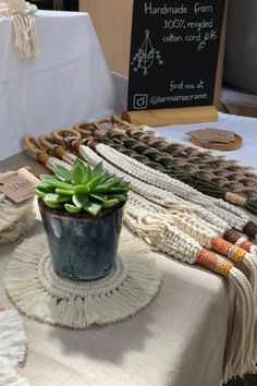 a table topped with a potted plant next to a sign and tassels