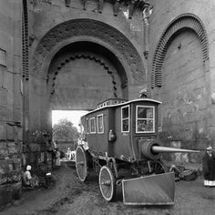 an old train car sitting in the middle of a tunnel with people standing around it