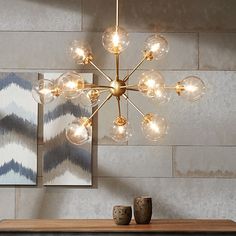 a modern chandelier hanging over a wooden table