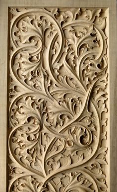 an intricate carving on the side of a building with flowers and swirls in it