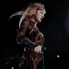 a woman in black and red dress holding a microphone