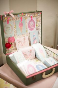 an open suitcase sitting on top of a table filled with cards and envelopes that say happy birthday