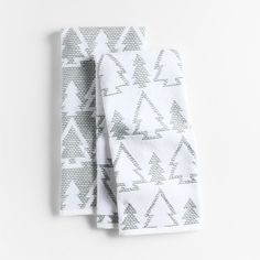 two towels folded on top of each other in front of a white background with grey triangles