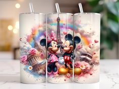 three disney mickey mouse travel mugs with the eiffel tower in the background