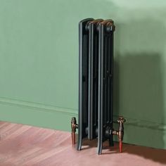 an old radiator sitting on the floor in front of a green painted wall