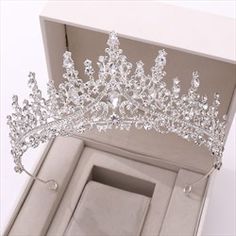 a tiara in a box with its lid open to show it's crystal stones