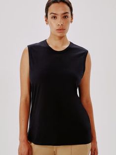 A feminine take on the classic muscle tee, our Sleeveless Tee skims the body and features strong detailing in the form of finished trim at the neck and arm. Designed to be worn loose or tucked, pair with our Archival 501s for sophisticated, classic casual.\nThe fibers used to create our 100% organic cotton blend continue to soften with age. The GOTS production standards practiced by our partners ban the use of hazardous chemicals and help promote healthy soils, ecosystems, and working conditions Fitted Sleeveless Athleisure T-shirt, Black Sleeveless Basic Muscle Tee, Black Relaxed Fit Tank Muscle Tee, Black Fitted Sleeveless Muscle Tee, Relaxed Fit Black Muscle Tank Tee, Black Fitted Tank Muscle Tee, Black Stretch Muscle Tee For Everyday, Black Stretch Muscle Tee, Classic Black Tank Top