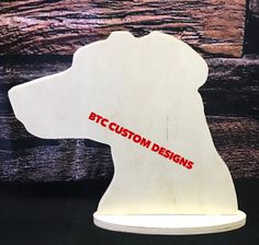 a wooden dog head with the word custom designs printed on it's back side