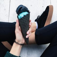 two people holding an ice cream cone with blue icing