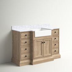 a white sink sitting on top of a wooden cabinet next to a counter with drawers