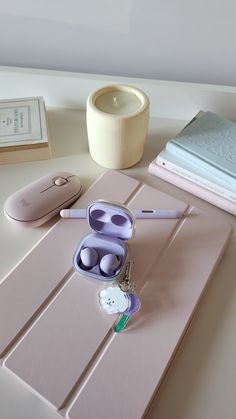 an assortment of items sitting on top of a table next to a cup and pen