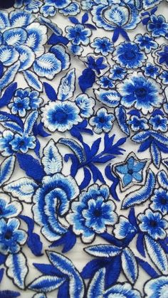 a blue and white floral print fabric with large flowers on the bottom half of it