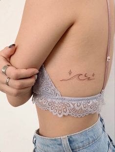 a woman with a tattoo on her stomach and the word love written in cursive writing