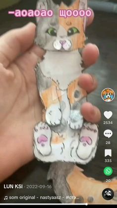 a person holding up a phone case with an image of a cat on it