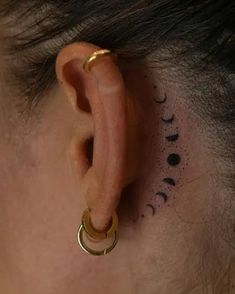 a person with a small tattoo behind their ear