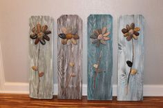 four painted wooden flowers are sitting on the floor