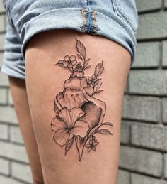 a woman's thigh with a flower tattoo on it