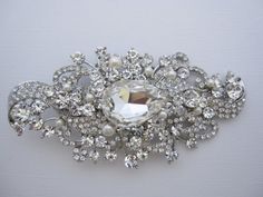 DIY Bouquet Broochces , Rhinestone Wedding Brooches, Silver Brooches, Wedding Cake Brooches. This beautiful Clear rhinestone Swarovski ivory pearl brooch is a perfect compliment for the wedding party or wedding gift. The brooch is measured approx 4.5" x 2.5".This brooch is a great compliment for bolero, wedding gown, evening dress,bridal sash or everyday dress. Tone color-- Silver tone Pearl color -- Swarovski white and ivory pearl or Fresh water pearl. Finish style -- Finish hair comb or Finish Elegant White Wedding Brooches, Elegant Diamond White Brooches For Wedding, Elegant Diamond White Wedding Brooches, White Rhinestone Brooches For Formal Occasions, Formal White Brooches With Rhinestones, Crystal Brooch For Wedding, Crystal Brooch For Wedding Jewelry, White Crystal Brooch For Formal Occasions, Formal White Crystal Brooches