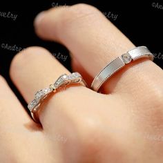 two wedding bands on top of each other in the palm of someone's hand