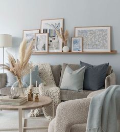 a living room filled with lots of furniture and pictures on the wall above it's coffee table