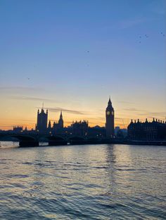 the big ben clock tower towering over the city of london, england at sunset or dawn