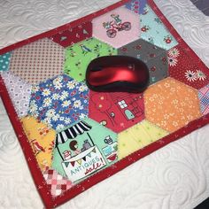 a computer mouse sitting on top of a patchwork quilt