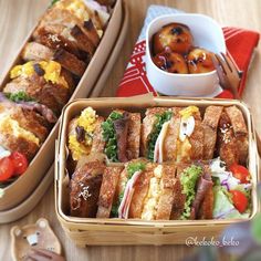 two wooden trays filled with sandwiches on top of a table next to each other