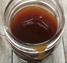 a jar filled with liquid sitting on top of a wooden table