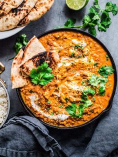 several different types of food are on the table, including rice and chicken with cilantro garnishes