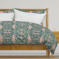 a bed with green and pink bedspread, pillows and pillow cases on it