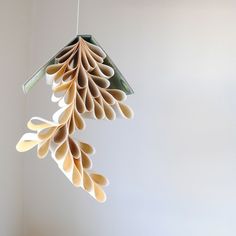 an origami bird feeder hanging from a string in the shape of a leaf