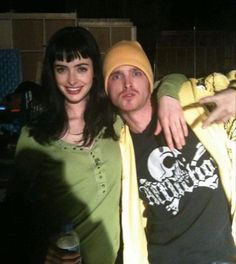 a man standing next to a woman wearing a yellow hat