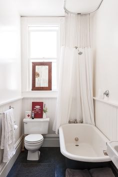 a white bath tub sitting next to a toilet in a bathroom