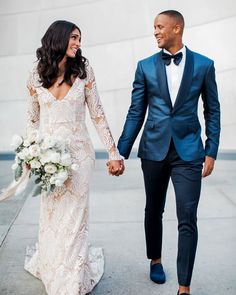 a man and woman in formal wear holding hands