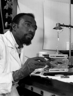 a man sitting in front of a microscope