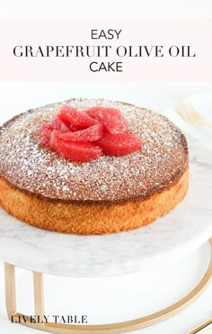 a cake with powdered sugar and raspberries on top sits on a marble plate