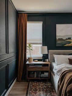 a bed room with a neatly made bed and a painting on the wall above it