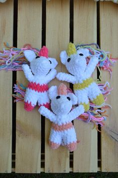 three crocheted stuffed animals sitting on top of a wooden bench