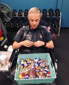 a police officer sitting in a wheel chair holding a box of candy and looking at it