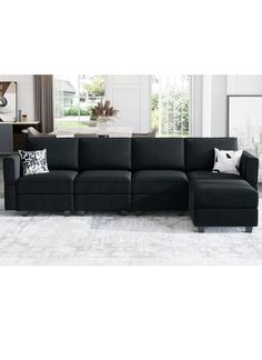 a living room with a black couch and white rug