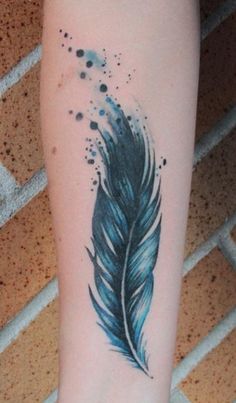 an image of a tattoo on someone's leg with a blue feather painted on it