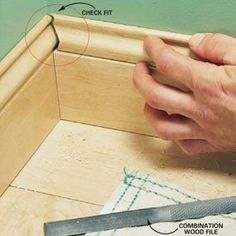 a man is working on wood trimming with a pair of scissors and a screwdriver