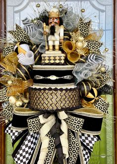 a christmas tree decorated with black and white ribbons, gold decorations and nutcrackers