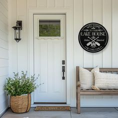 a white front door with a wooden bench and potted plant on the porch next to it