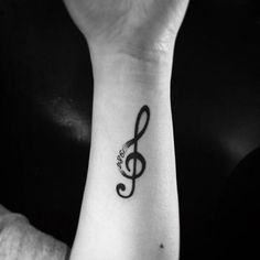 a person with a tattoo on their wrist has a musical note tattooed on her arm