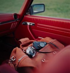 a camera sitting on top of a brown bag in the back seat of a car