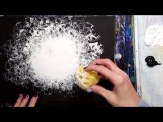 a person is holding an apple in front of a painting with white powder on it